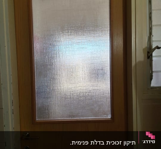 דלת עץ עם זכוכית מטושטשת במרכז